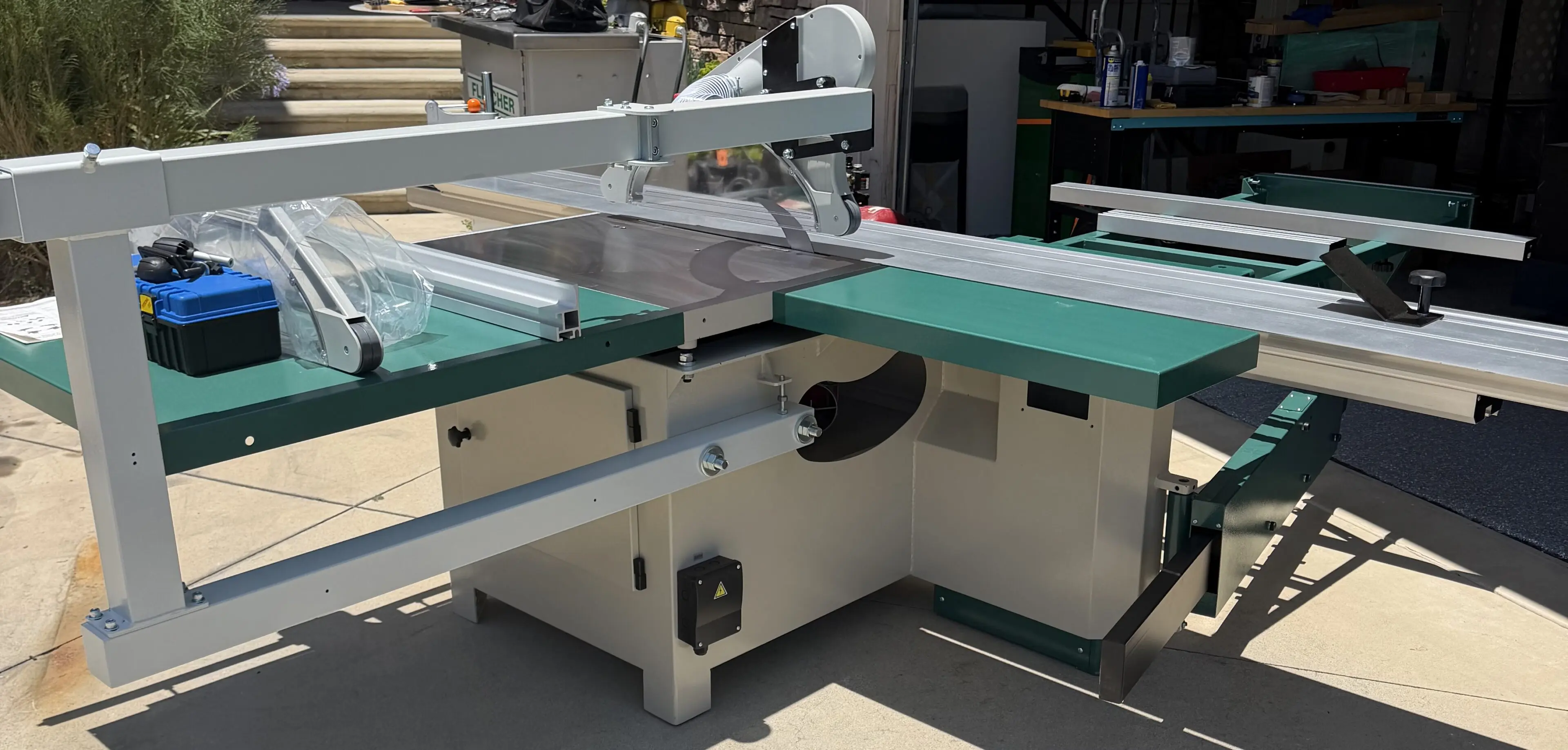 Green sliding table saw in workshop
